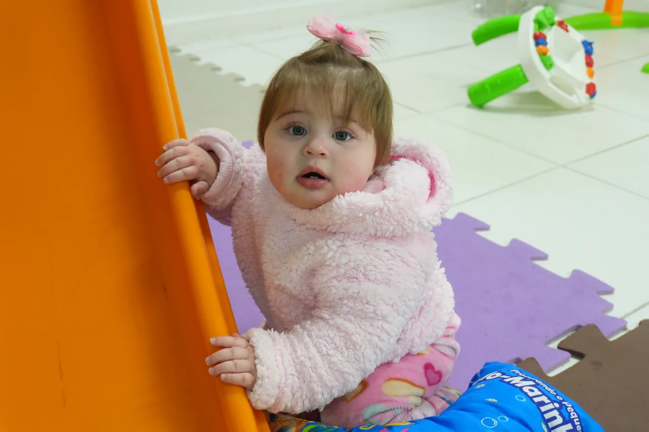 Bebê no berçário junto ao escorregador