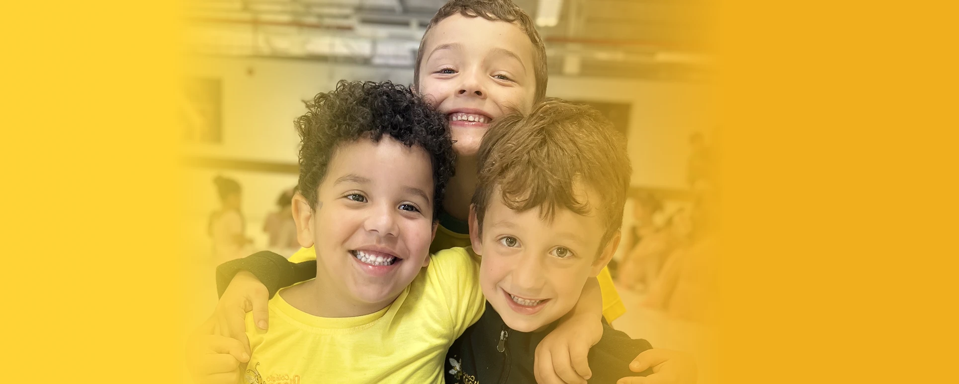 Três crianças sorrindo na escola